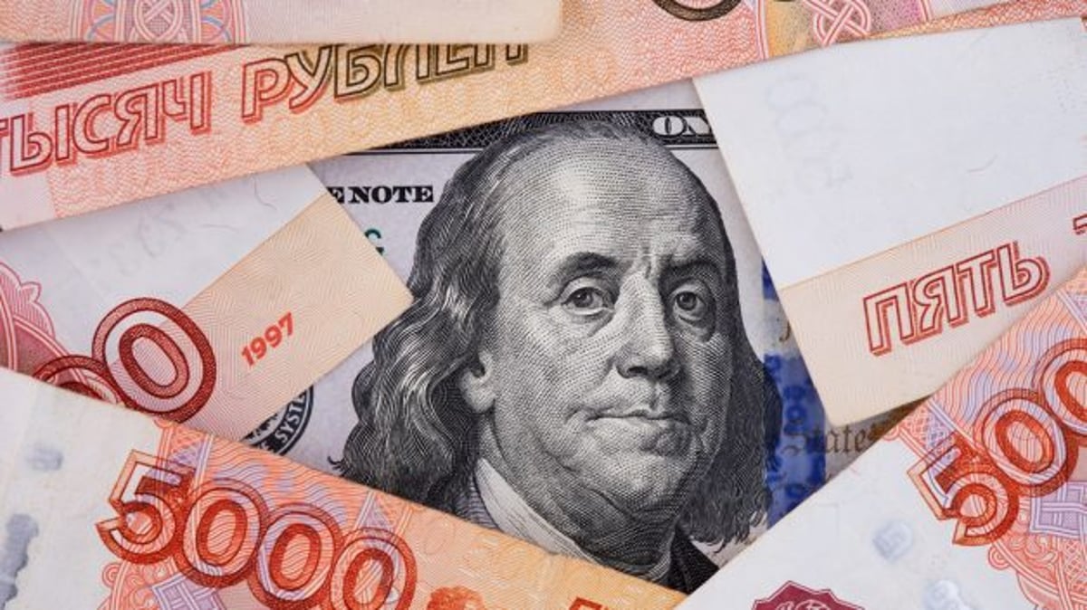 Cédulas de rublo russo em volta de uma cédula de dólar, simbolizando a taxa de câmbio entre os países