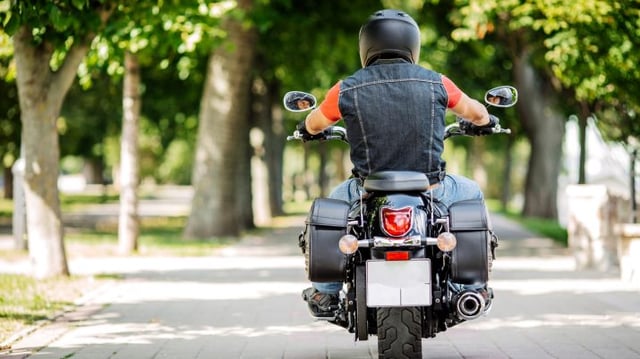 Homem anda de moto com roupa esportiva