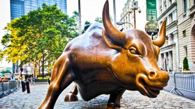 Estátua de Touro em frente à bolsa de Nova York; índices ajudam bitcoin (BTC) hoje