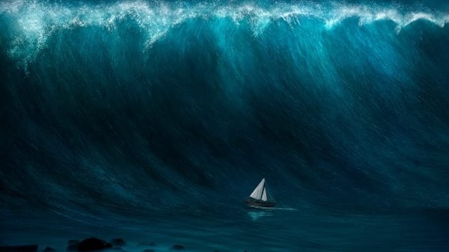 Barco a vela navegando em um mar turbulento, com onda gigante