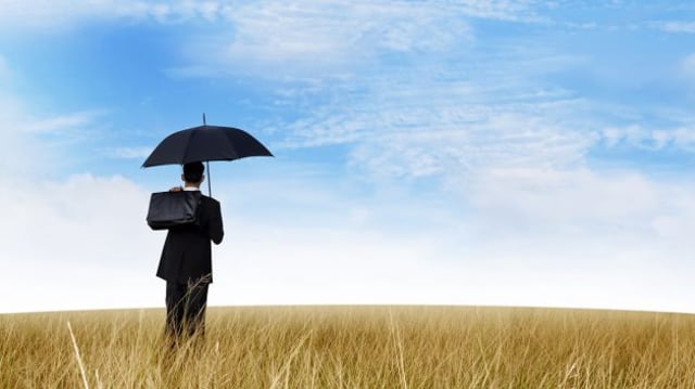 Homem de negócios usa guarda-chuva em dia de sol
