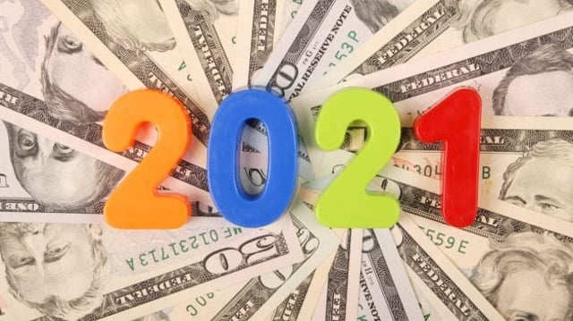 Número '2021' em cima de pilha de dinheiro