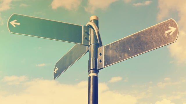 Blank,Directional,Road,Signs,Against,Blue,Sky.,Black,Metal,Arrows