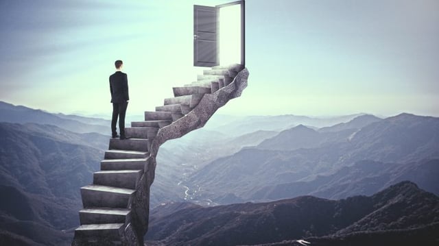 Businessman,Standing,On,Stairs,With,Abstract,Open,Door.,Landscape,Background.