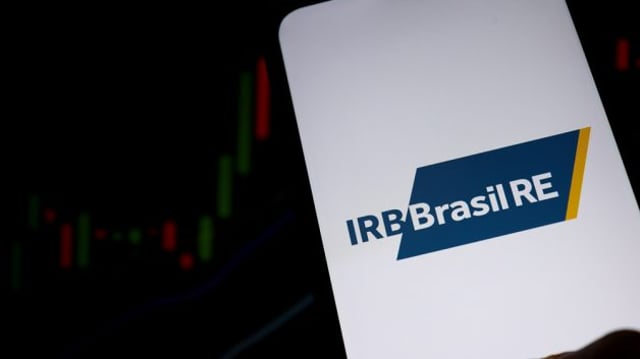 Tela de celular mostra logotipo do IRB Brasil RE com gráfico ao fundo