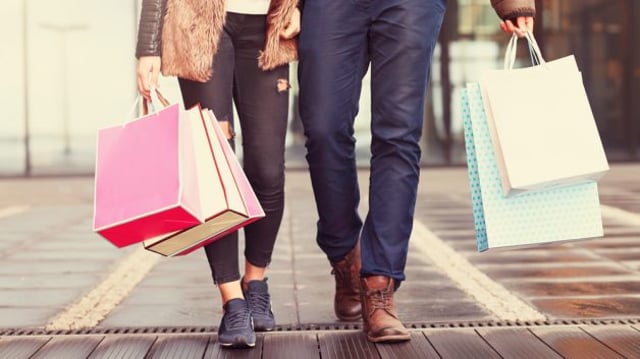 casal carrega sacolas de compras em shopping