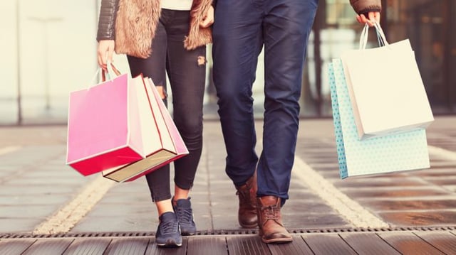 casal carrega sacolas de compras em shopping