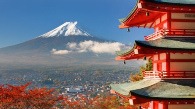 Construção em estilo japonês em primeiro plano; ao fundo, o monte Fuji, um dos símbolos do Japão
