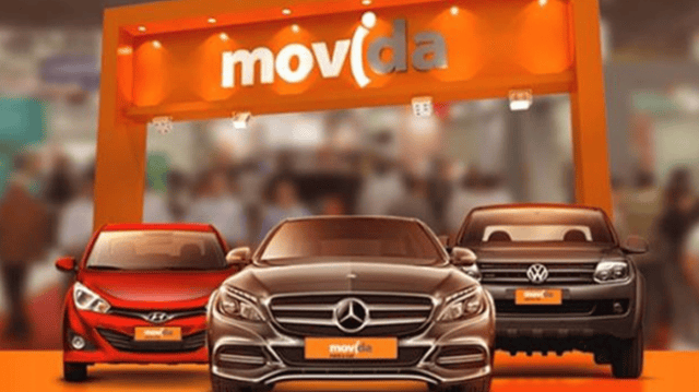 Três carros em frente a um arco com as cores e logo da Movida (MOVI3)