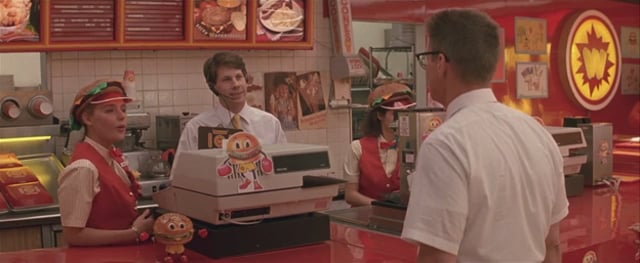 cena do filme "Um Dia de Fúria (1993)" onde um home está fazendo um pedido no caixa da lanchonete