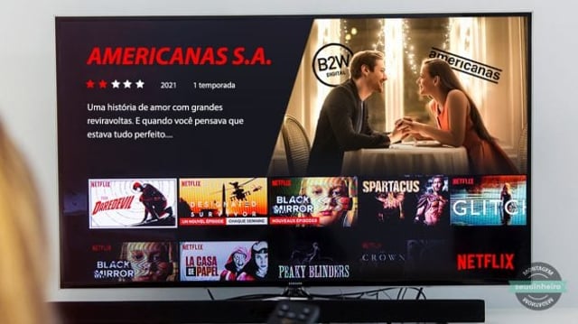 Montagem de pessoa apontando o controle para tv com série na Netflix de nome Americanas S.A. e ao lado um casal em jantar romântico, o homem com o logo da B2W atrás e mulher com o logo da americanas atrás