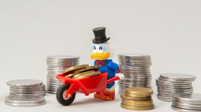 Miniatura do tio patinhas com um carrinho de mão e cercado de pilhas de moeda | Dividendos fundos imobiliários XPCM11