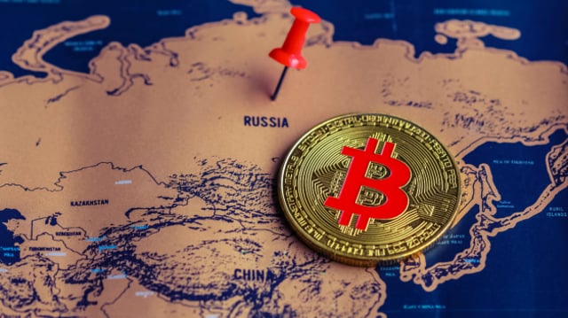 Bitcoin ao lado do mapa da Rússia com um pino vermelho em cima