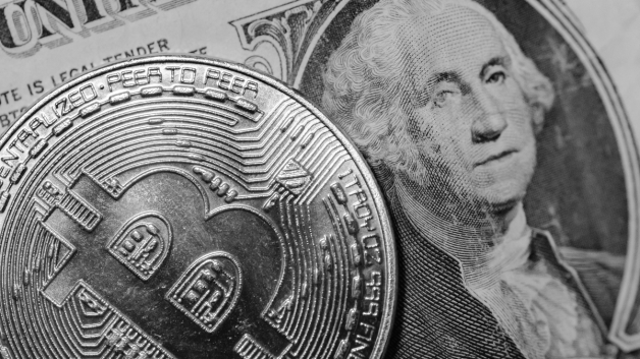 Bitcoin em cima de um dólar em preto e branco