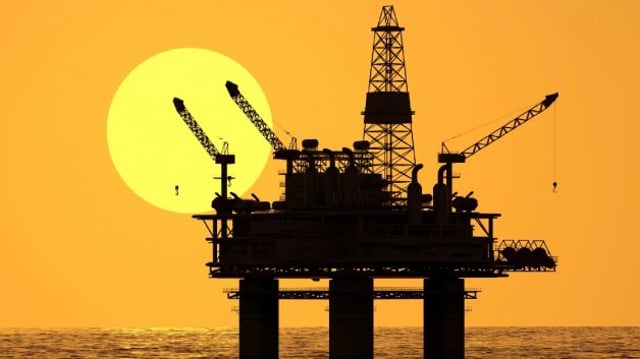 Ilustração de uma plataforma de petróleo no mar, com o pôr do sol ao fundo. Representação de empresas petroleiras, como Petrobras (PETR4), PetroRio (PRIO3) e Dommo (DMMO3)