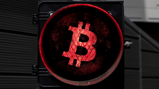 Bitcoin em uma luz vermelha sinalizando a parada do mercado de criptomoedas