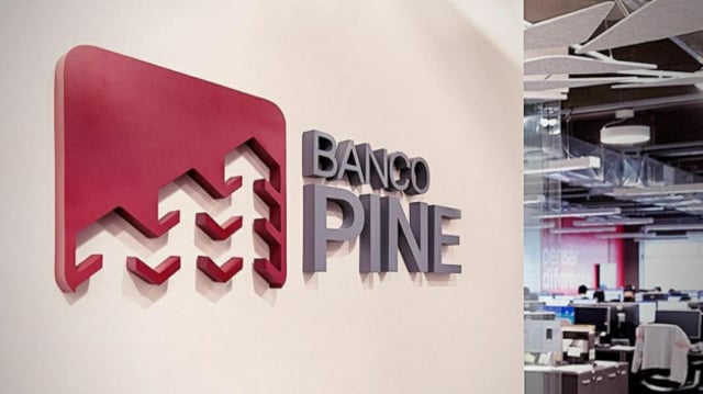 Parede branca com logotipo do Banco Pine no escritório da empresa