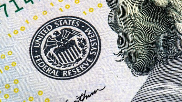 Cédula de dólar vista com zoom, focada no logo do Federal Reserve (Fed)