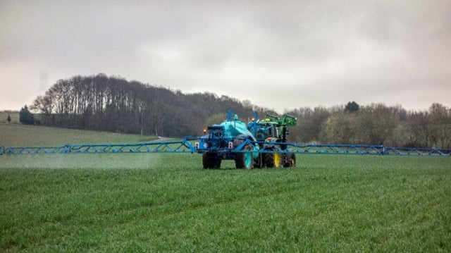 Imagem mostrando uma máquina agrícola aplicando fertilizantes no solo. Representa as empresas desse setor na bolsa, como a Fertilziantes Heringer (FHER3 e FHER4) e Vittia (VITT3)