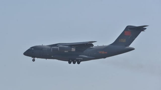 Avião militar cinza em pleno voo