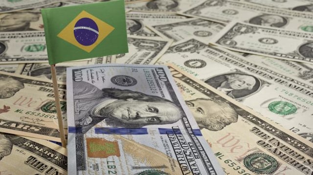 Bandeira do Brasil sobre cédulas de dólar