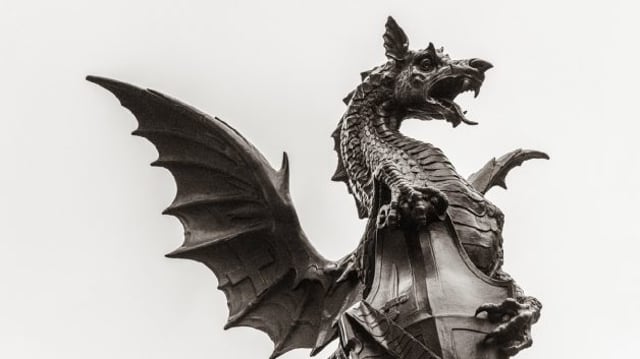 Estátua de dragão com as asas abertas, em preto e branco. Simboliza o comportamento da inflação e os rumos das taxas de juros