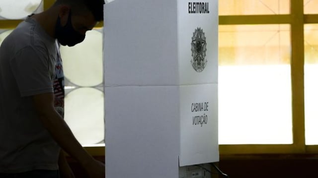 Homem vota na urna eletrônica, na cabine eleitoral | Votação eleições 2022