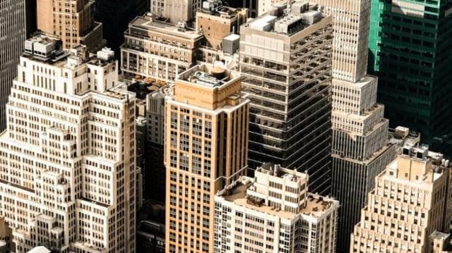 Vista aérea de uma aglomeração de edifícios de escritórios e casas | Fundos imobiliários