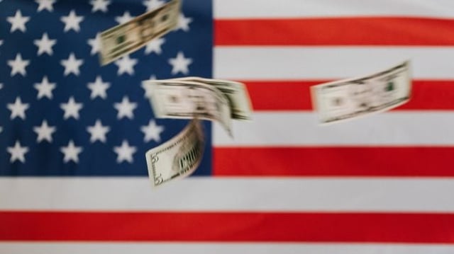 notas de dólar voando em frente a bandeira dos EUA