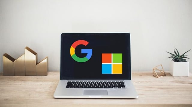 Notebook aberto com os logos do Google/Alphabet e da Microsoft na tela