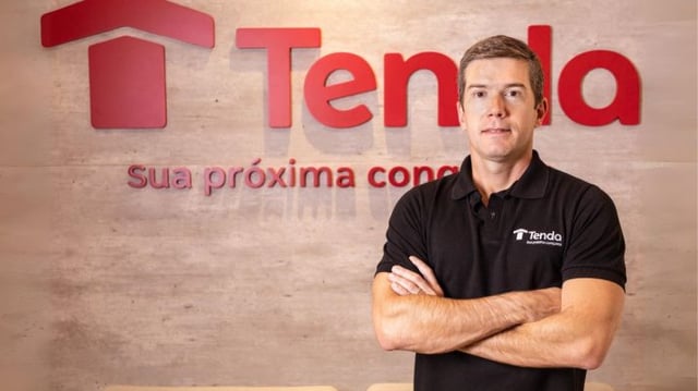 Fotografia do CFO da Tenda, Luiz Garcia, em frente ao logo da companhia