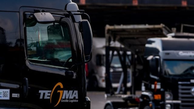 Caminhões pretos com o logo da Tegma