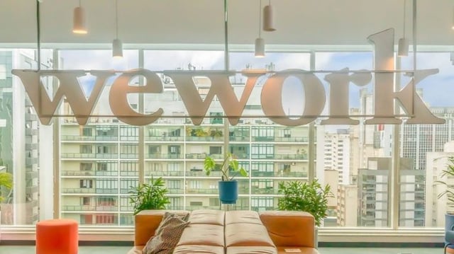 Fotografia de um escritório com o letreiro da WeWork, empresa que loca imóveis de fundos imobiliários