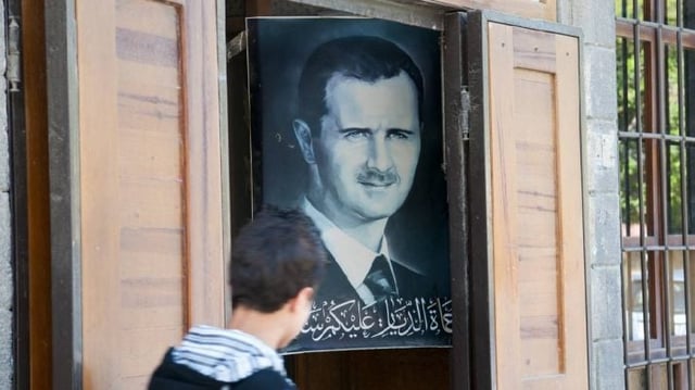 Cartaz com a imagem de Bashar al-Assad