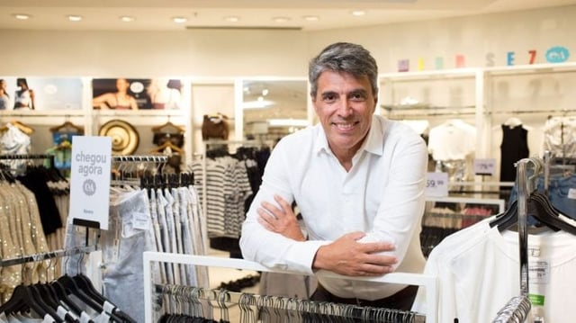 Paulo Correa, CEO da C&A, diante de uma arara de roupas na loja