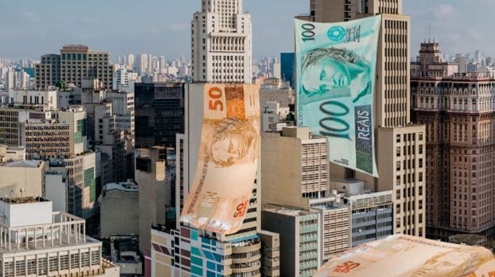 Montagem com prédios com notas de dinheiro representando fundos imobiliários dividendos