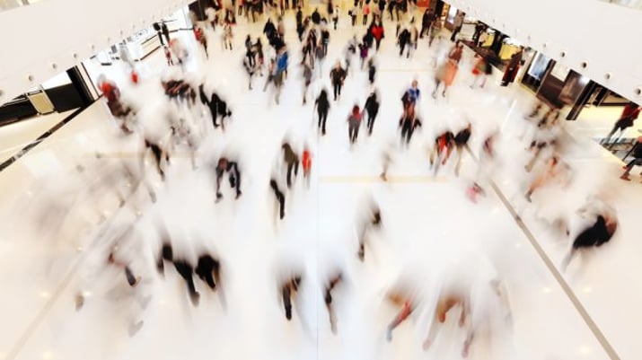 Varejo: imagem desfocada de pessoas caminhando em um shopping center