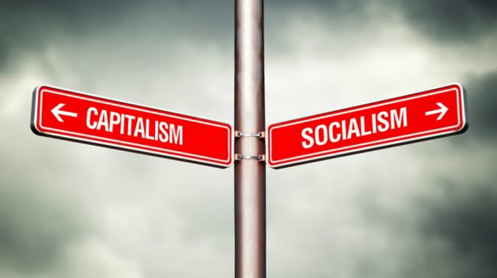 Placas com escritos de capitalismo e socialismo apontam para direções opostas
