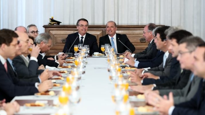 Bolsonaro ao centro de uma mesa na Reunião do Conselho do Gorveno