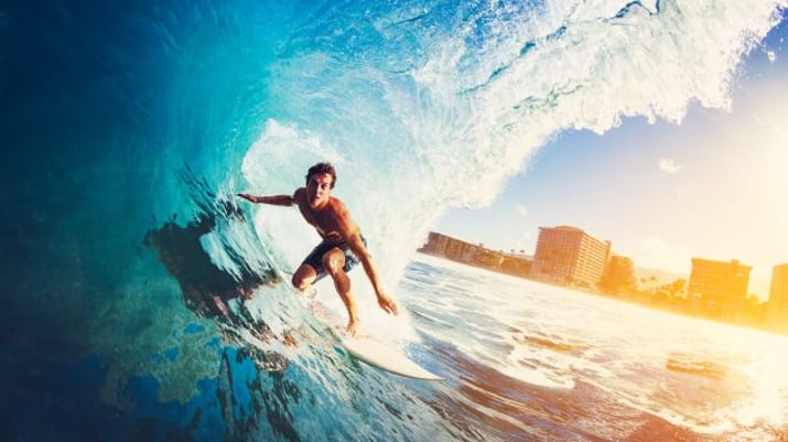 Surfista passa no meio de onda