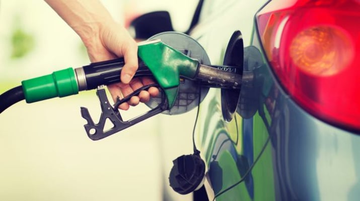 Mão abastecendo carro com etanol ou gasolina