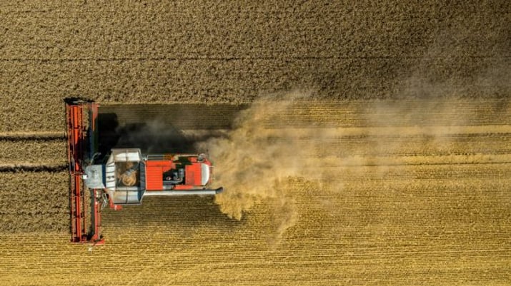 vista aérea do campo, com uma máquina agrícola localizada mais ao lado esquerdo