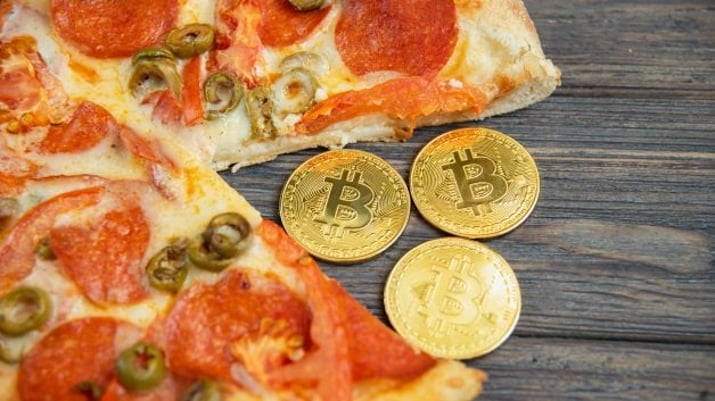Pizza com moedas ilustrativas de Bitcoin