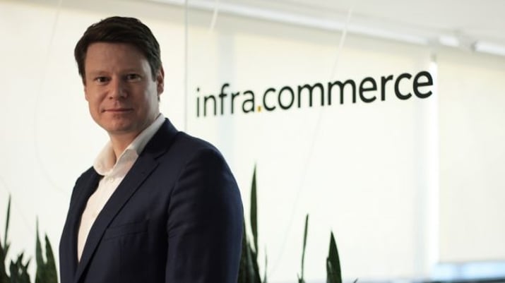 Retrato de Kai Schoppen, fundador e CEO da Infracommerce (IFCM3). O logo da empresa aparece ao fundo