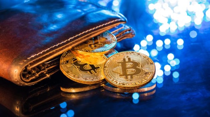 Carteira com moeda simbolizando o bitcoin