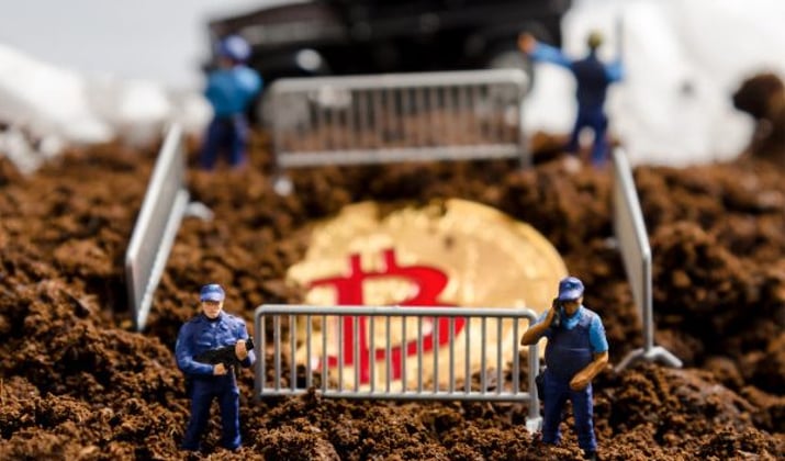 Policiais em miniatura cercam um bitcoin parcialmente enterrado | Coinbase Criptomoedas