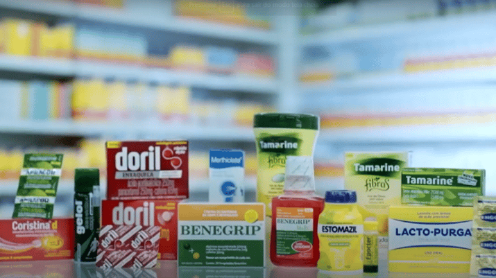 Imagem mostrando uma série de medicamentos que fazem parte do portfólio da Hypera (HYPE3); em segundo plano, aparecem prateleiras de uma farmácia