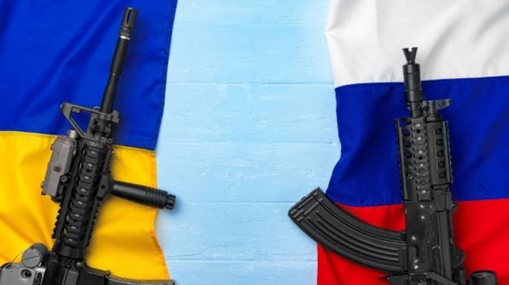 Bandeiras da Ucrânia e da Rússia com armas simbolizando conflito
