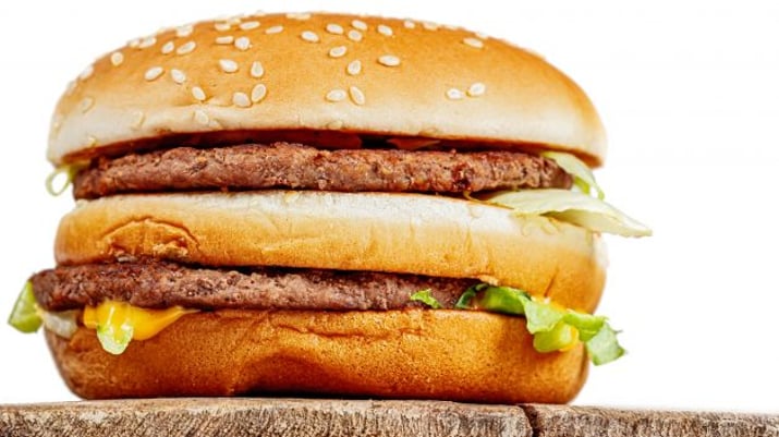 Foto de um Big Mac sobre uma bancada de madeira