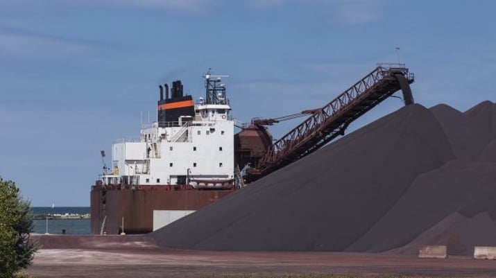 Carregamento de minério de ferro sendo despejado de navio; simboliza a Vale (VALE3) e outras grandes mineradoras do mundo, além de siderúrgicas como CSN (CSNA3), Gerdau (GGBR4) e Usiminas (USIM5)